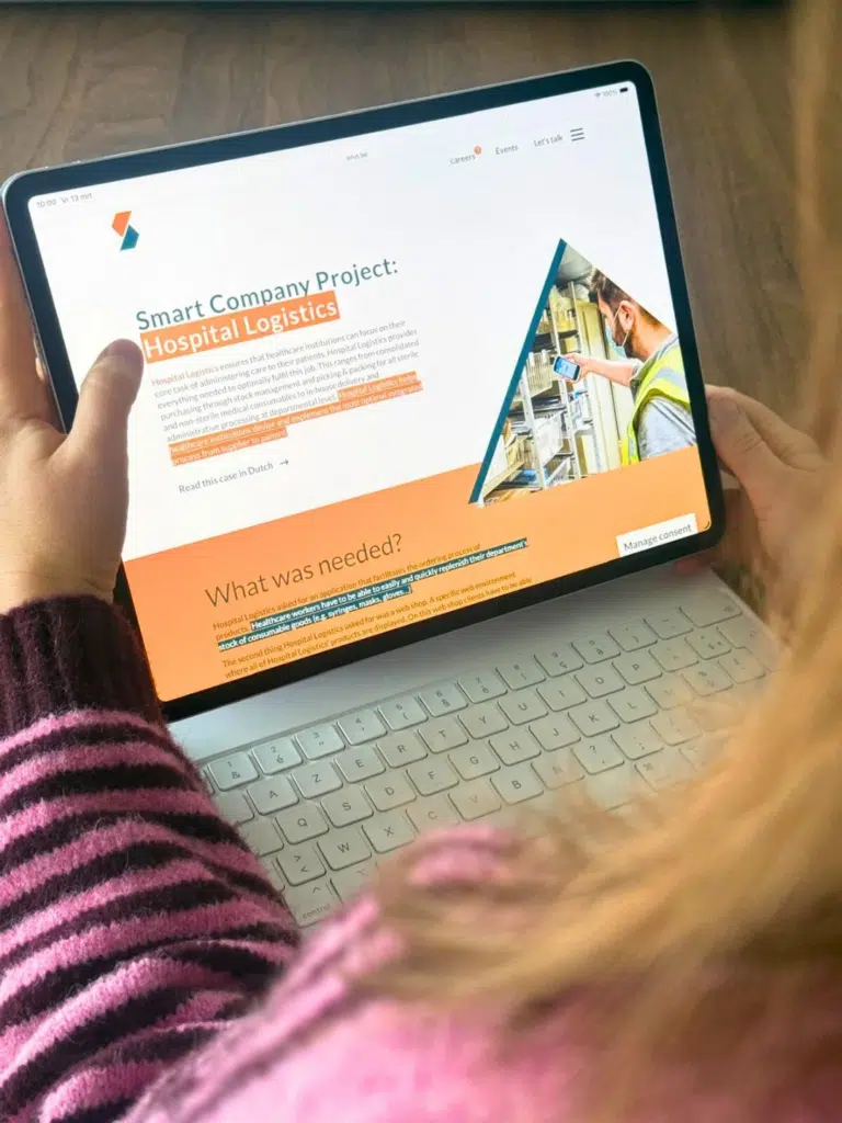 Persoon houdt iPad vast met daarop de Sirus-website met het Smart Company Project Hospital Logistics, ontworpen door Gravitei
