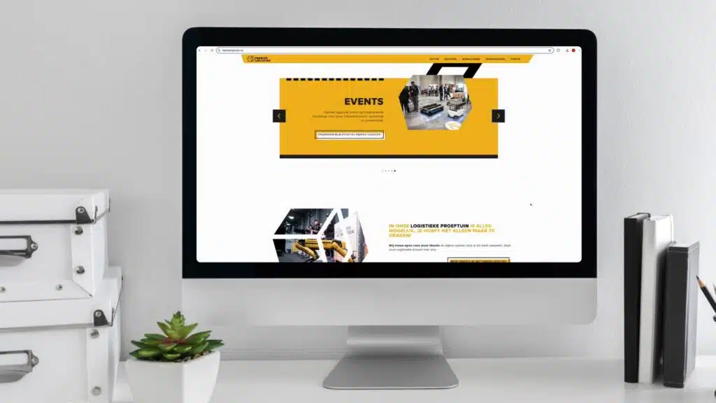 Fabriek Logistiek website weergegeven op een desktopmonitor met gele hero-banner over events en logistieke proeftuin