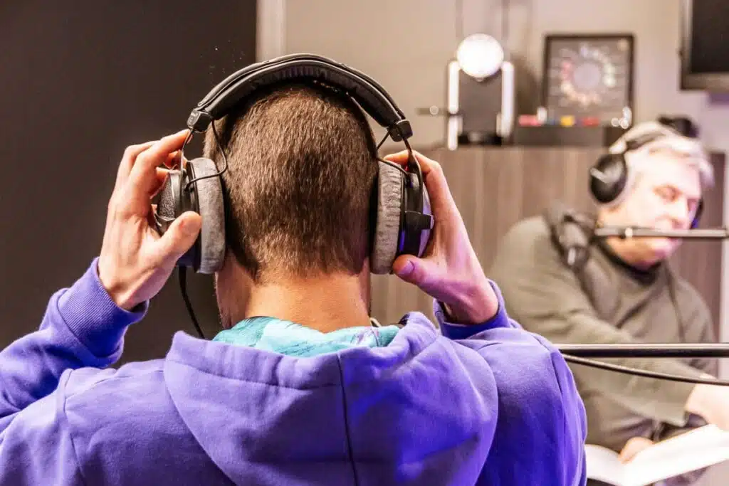 Man met koptelefoon luistert naar BeMedico podcast in moderne studio setting