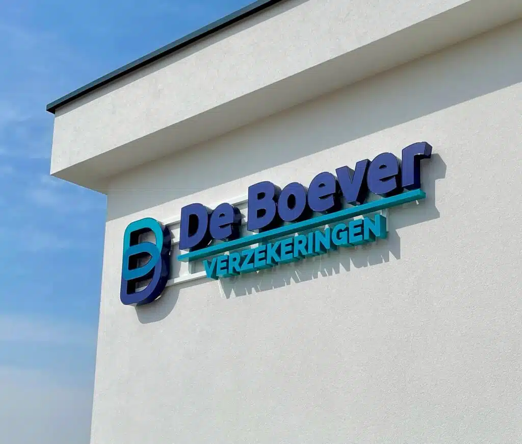 Gebouw met het logo van De Boever Verzekeringen aan de gevel, met blauwe en turquoise letters tegen een witte achtergrond.