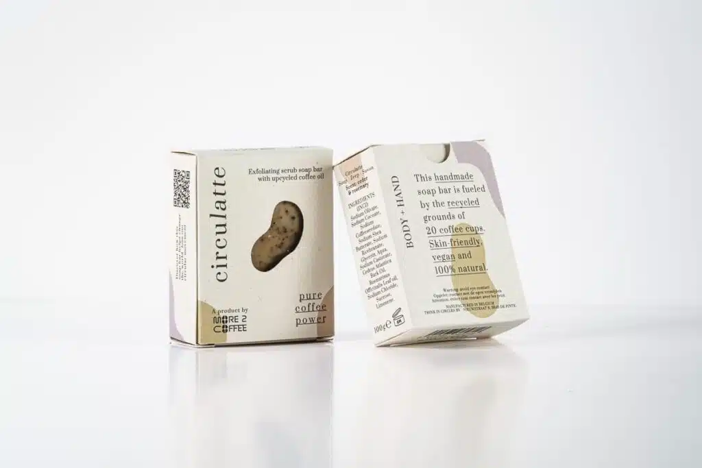 Twee verpakkingen van circulatte zeep, gemaakt met gerecyclede koffie, met tekst die de natuurlijke en veganistische eigenschappen benadrukt.