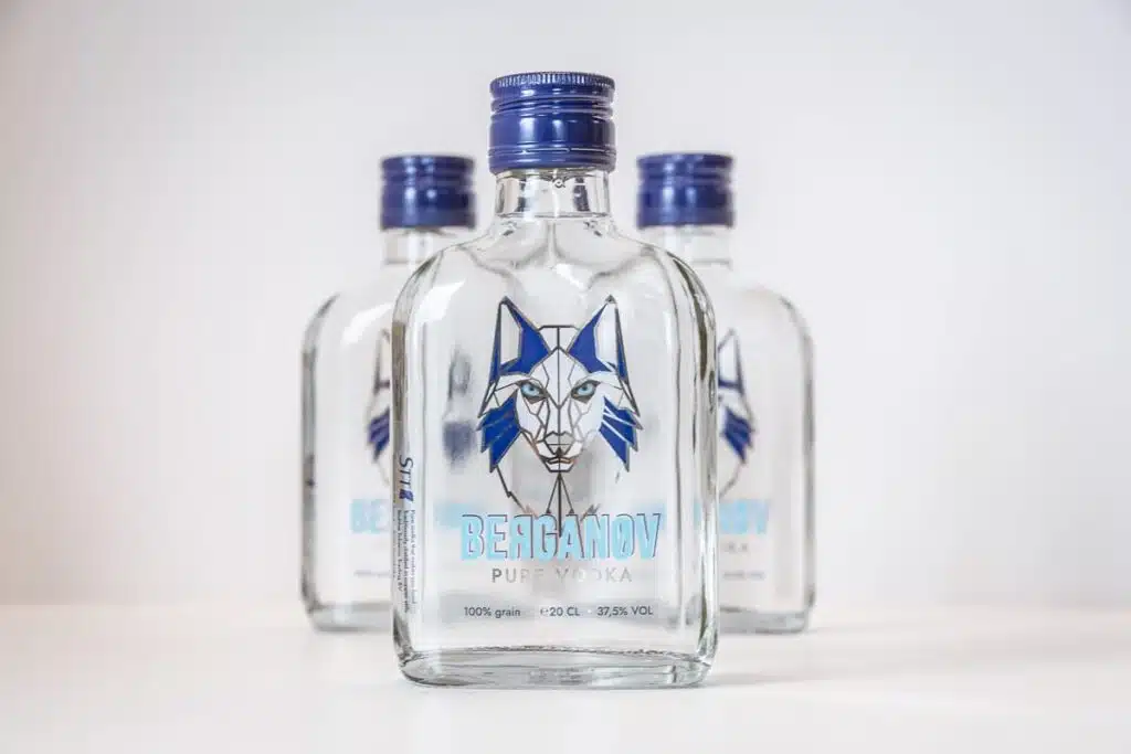 Drie flessen Berganov Pure Vodka naast elkaar, met blauwe schroefdoppen en het lynxlogo op de etiketten
