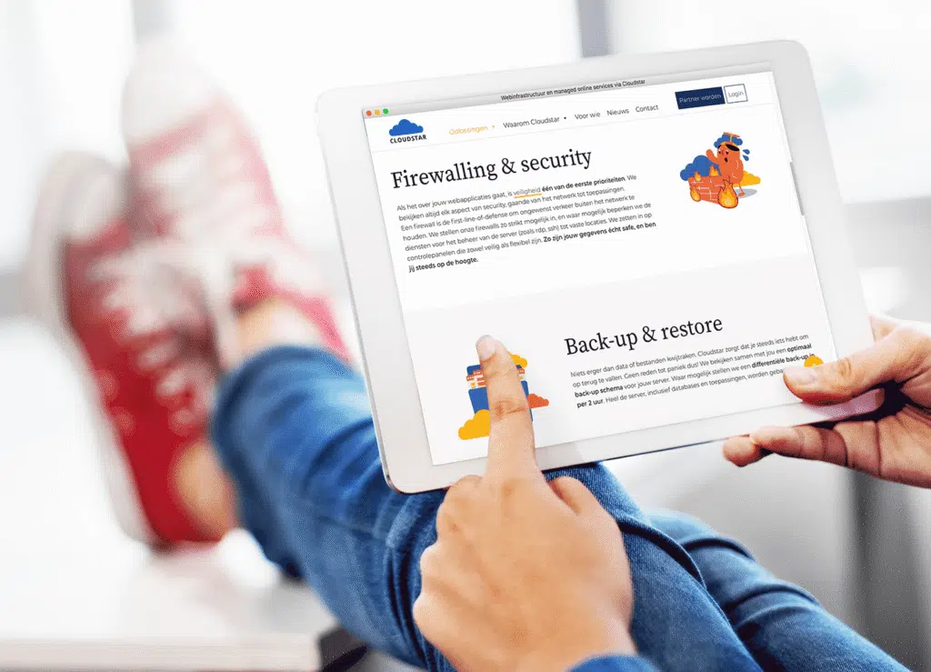 Een persoon bekijkt een tablet terwijl hij of zij de website van Cloudstar bekijkt met informatie over firewalls en back-up en herstel.
