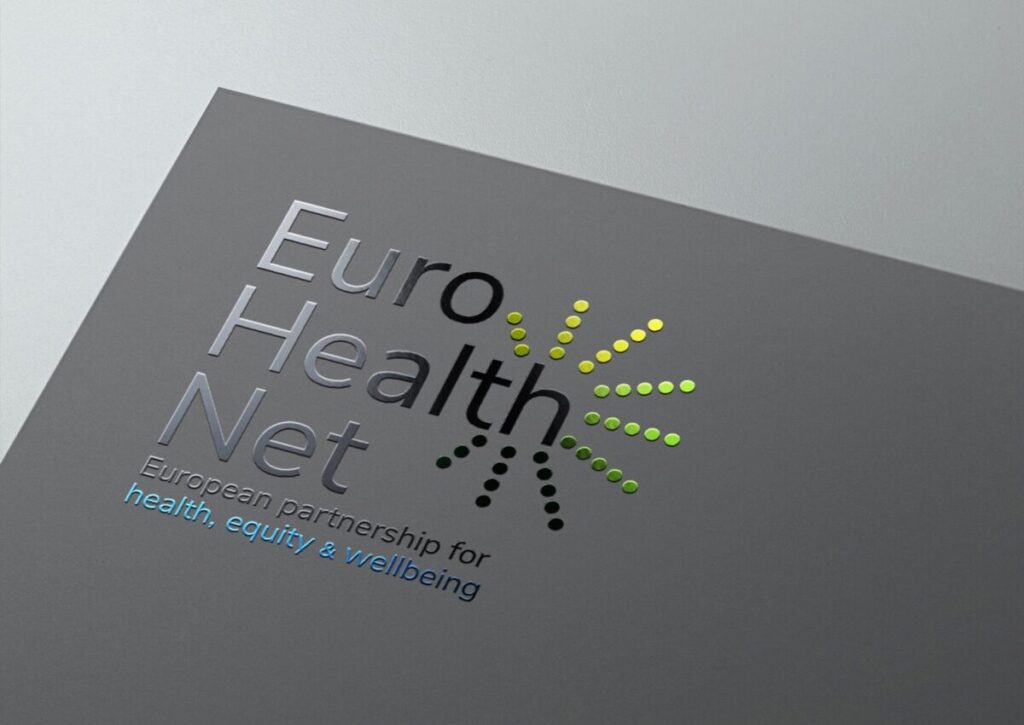EuroHealthNet Gedrukt Logo: Een close-up van het EuroHealthNet-logo op grijs papier, met een glimmende, reliëfdruk van de tekst.