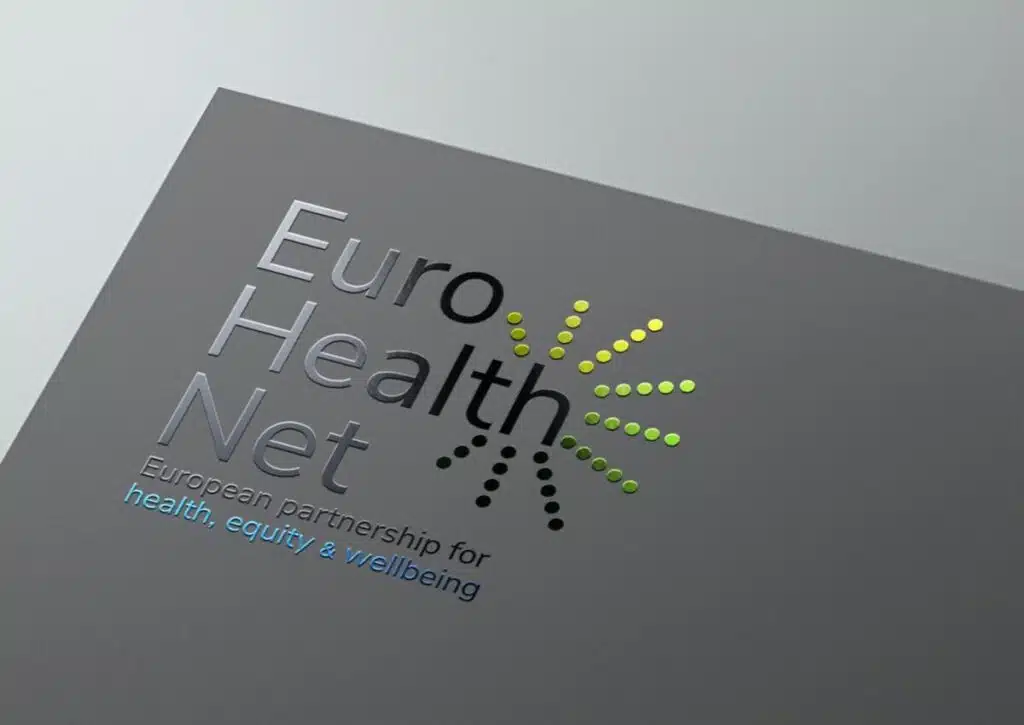 EuroHealthNet Gedrukt Logo: Een close-up van het EuroHealthNet-logo op grijs papier, met een glimmende, reliëfdruk van de tekst.