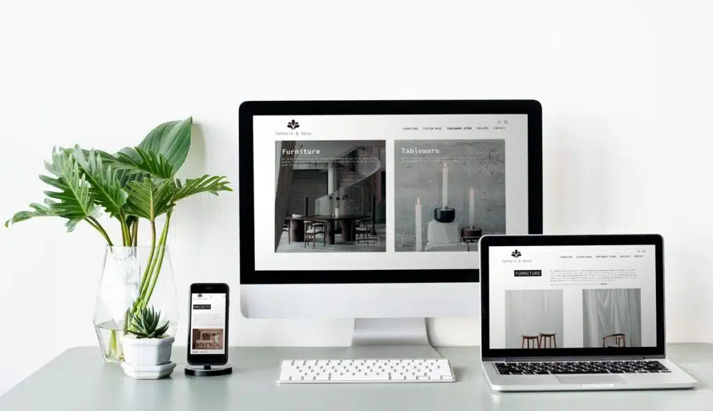 Een moderne werkruimte met daarop de website van 'fontein & bova' weergegeven op een desktopcomputer, een laptop en een smartphone. De website toont categorieën voor meubels en serviesgoed.