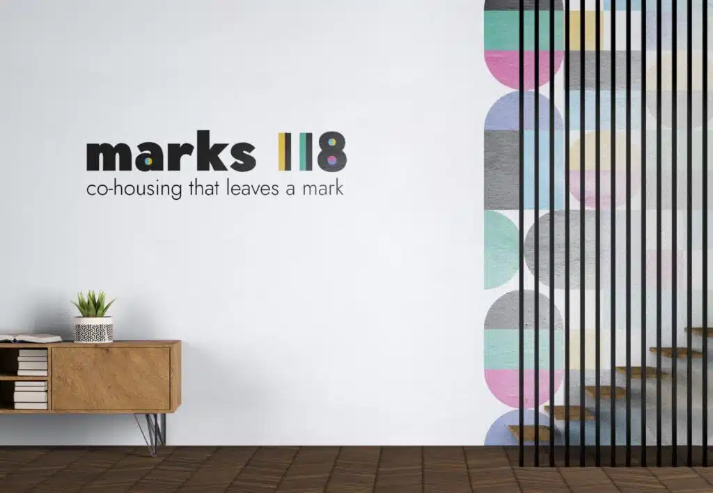 Marks118 logo mockup op witte muur met houten dressoir en kleurrijk cirkelspatroon — co-housing branding door Graviteit