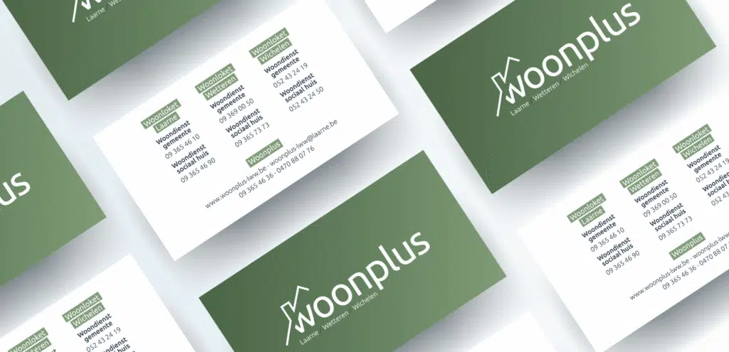 Visitekaartjes van Woonplus met groene en witte ontwerpen, uitgestald op een lichtgrijze achtergrond.