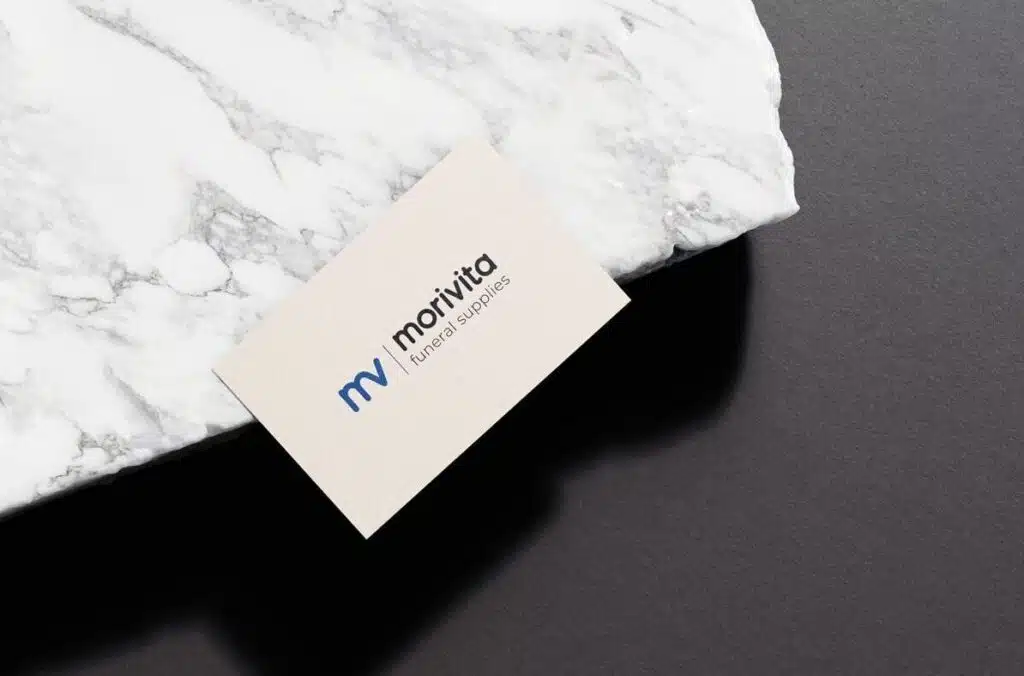 Morivita Funerals Supplies Kaartje op Marmer (Wit): Een wit visitekaartje met het logo van Morivita Funeral Supplies ligt op een marmeren oppervlak, met een strakke en professionele uitstraling.