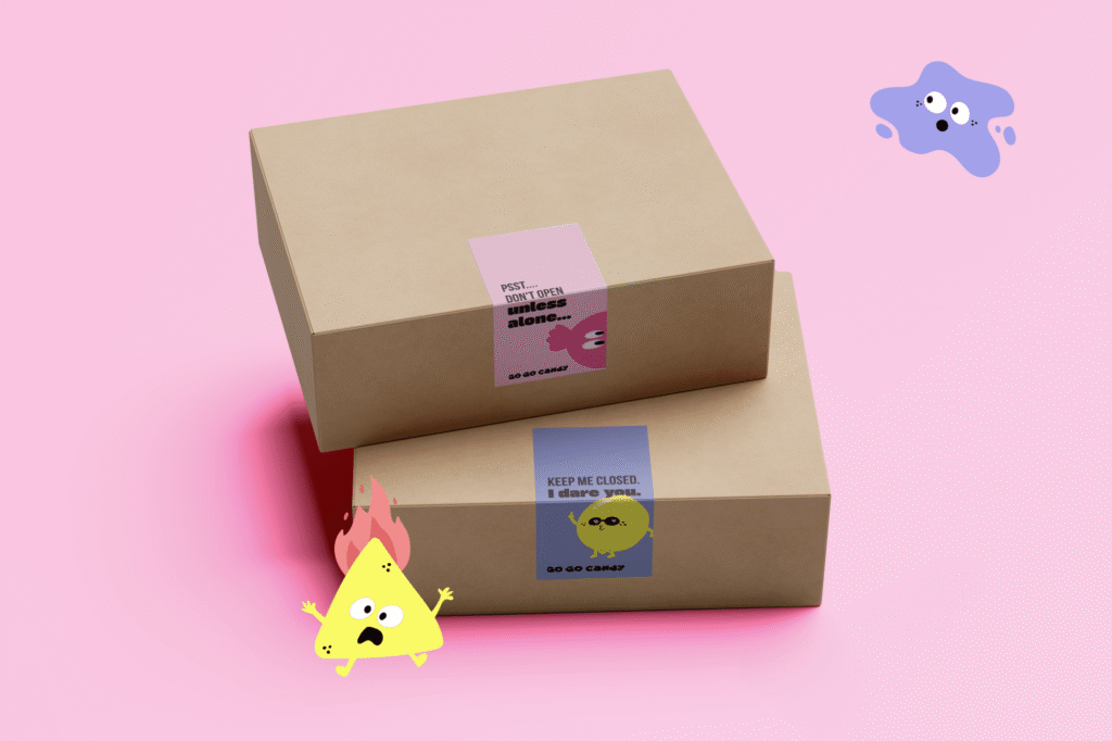 Twee kraft geschenkdozen van Go Go Candy met speelse stickers en vrolijke snoepmannetjes op roze achtergrond