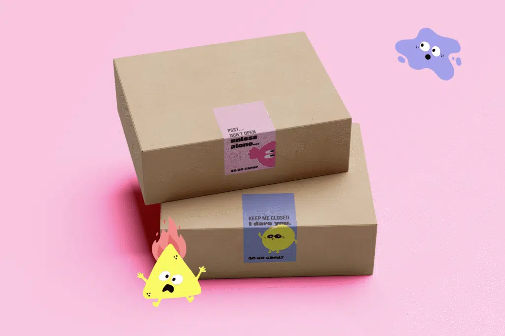 Twee kraft geschenkdozen van Go Go Candy met speelse stickers en vrolijke snoepmannetjes op roze achtergrond