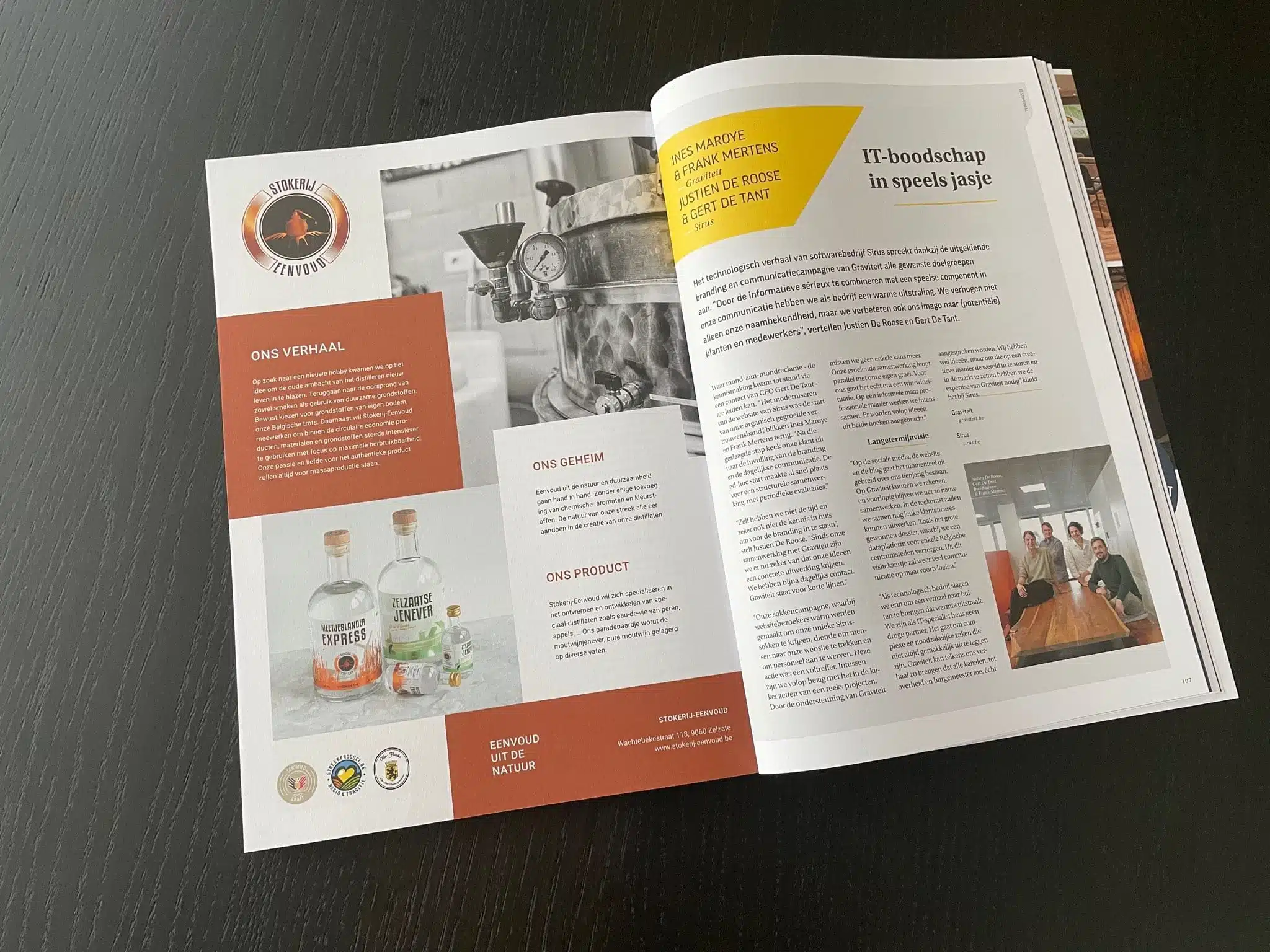 Een opengelegde magazinepagina met artikelen over Sirus met Ines Maroye en Frank Mertens van Graviteit en Justien De Roose en Gert De Tant van Sirus, met foto van Ines, Frank, Justien en Gert aan een tafel.