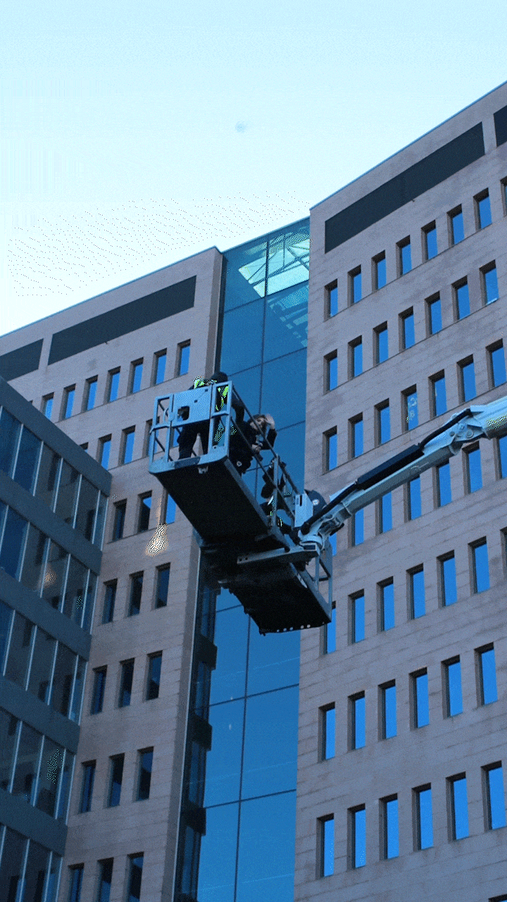 De fotoshoot bij de Zuiderpoort, waar Aeneas 50 meter de lucht in ging op een hoogtewerker om foto’s te nemen van ramenwassers.