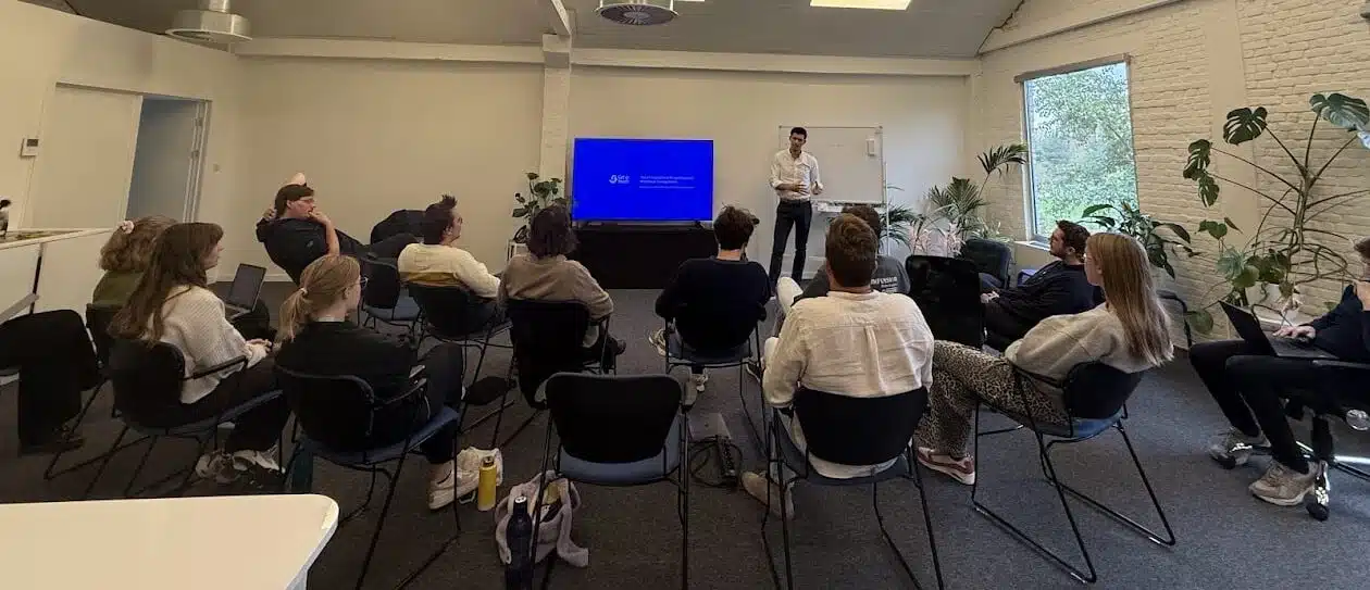 Graviteit teammeeting over WhatsApp-communicatie met Get In Touch presentatie op groot scherm
