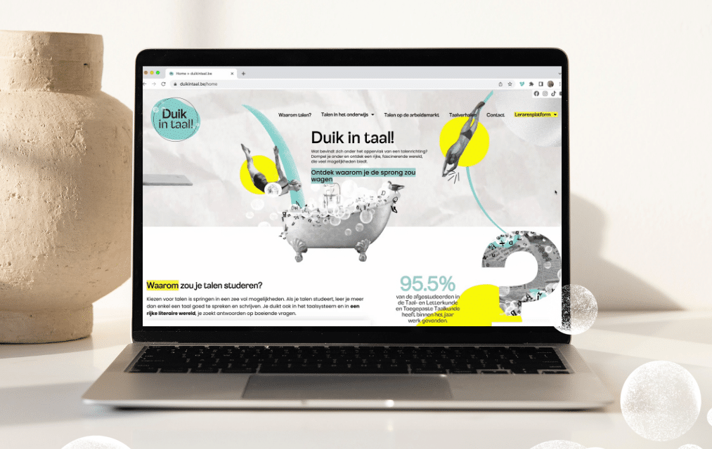 Een laptop op een bureau toont de website van "Duik in Taal!" met een kleurrijke illustratie van een duikende figuur en tekst die de voordelen van het studeren van talen benadrukt.