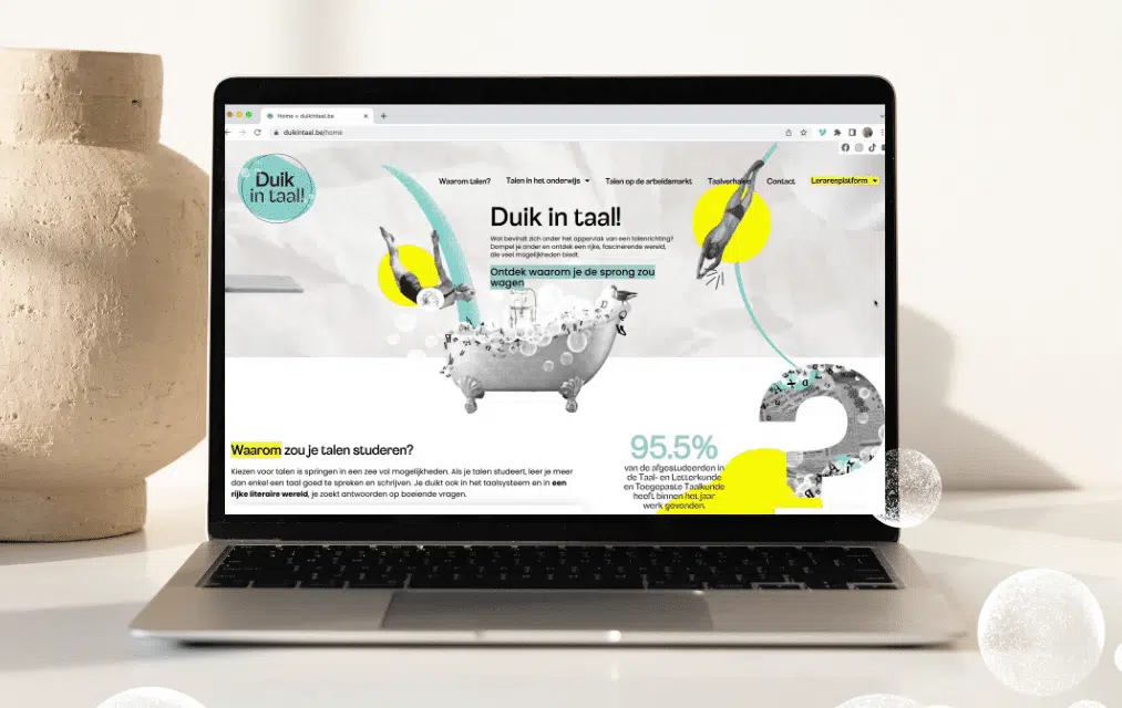 Een laptop op een bureau toont de website van "Duik in Taal!" met een kleurrijke illustratie van een duikende figuur en tekst die de voordelen van het studeren van talen benadrukt.