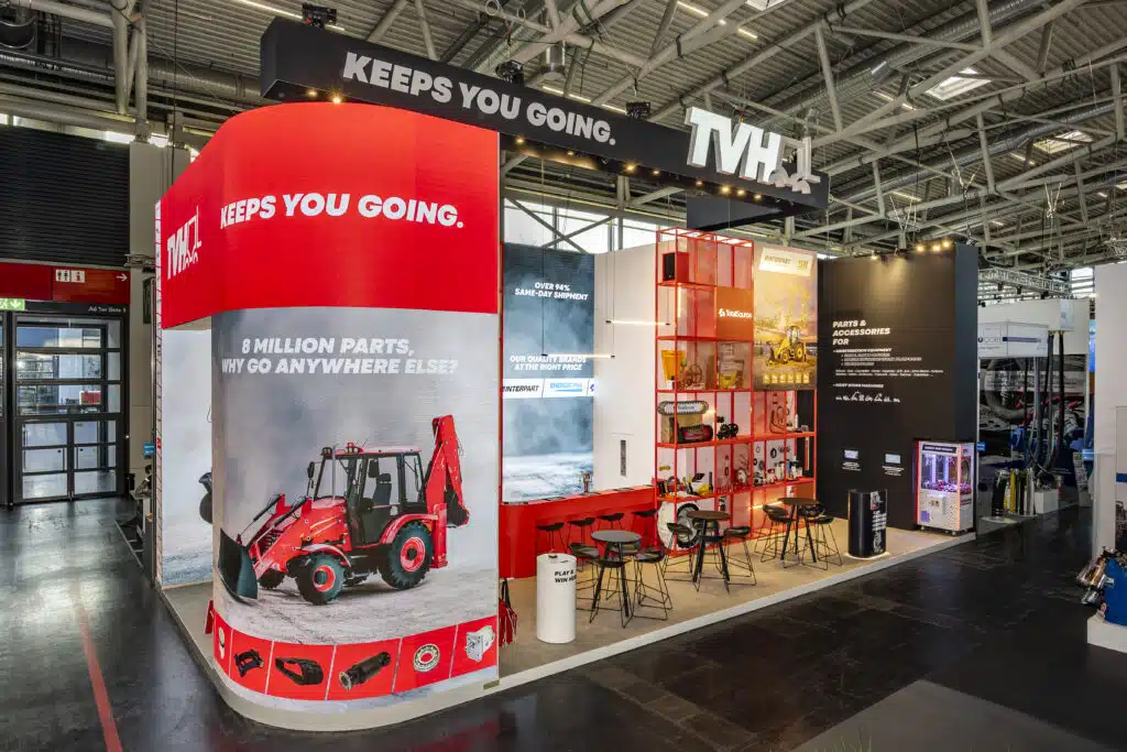 TVH-beursstand op Bauma München met rode ledwall, slogan 'Keeps You Going' en display van onderdelen voor bouwmachines, gebou