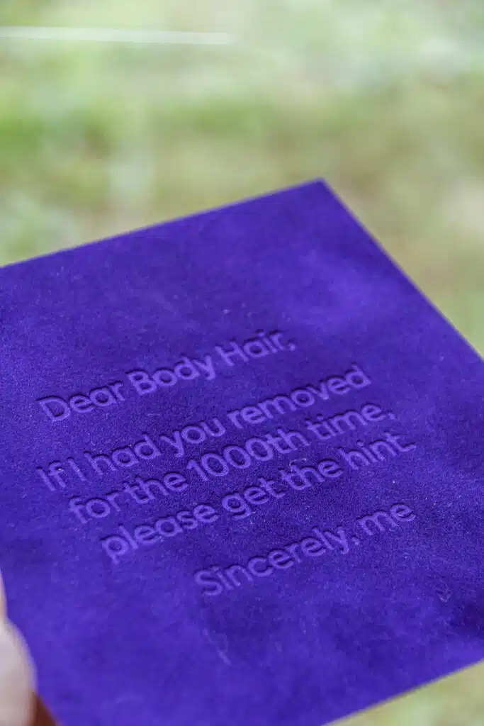 Paarse suède kaart met tekst 'Dear Body Hair, if I had you removed for the 1000th time, please get the hint' – BeMedico ontha