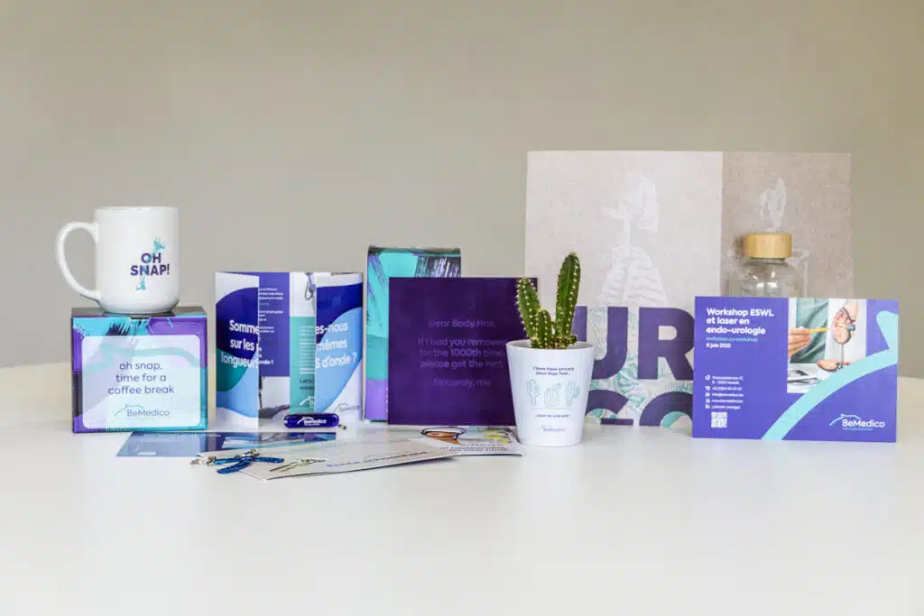 BeMedico campagnemateriaal: mok, cactusplantje, paarse kaarten, brochures, drinkfles en uitnodiging voor workshop ESWL en las