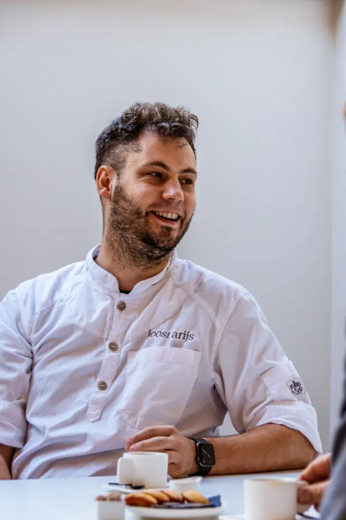 Meesterchocolatier Joost Arijs lacht tijdens een fotoshoot voor de BeMedico eindejaarscampagne 2022, gekleed in zijn witte ko