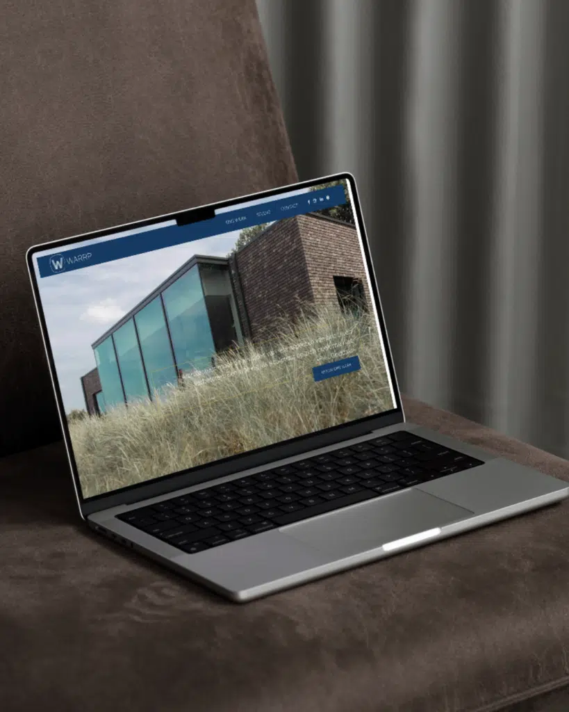 Laptop met het WARRP website mockup gemaakt door Graviteit, creatief communicatiebureau in Gentbrugge, met een moderne archit